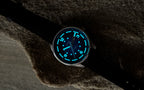 Bower Tide Seeker watch in low light, showing glowing blue luminescent markers using Swiss Super-LumiNova and hands on a Deep Blue dial. Resting on textured rock, the watch highlights its readability in dark environments and rugged outdoor styling.