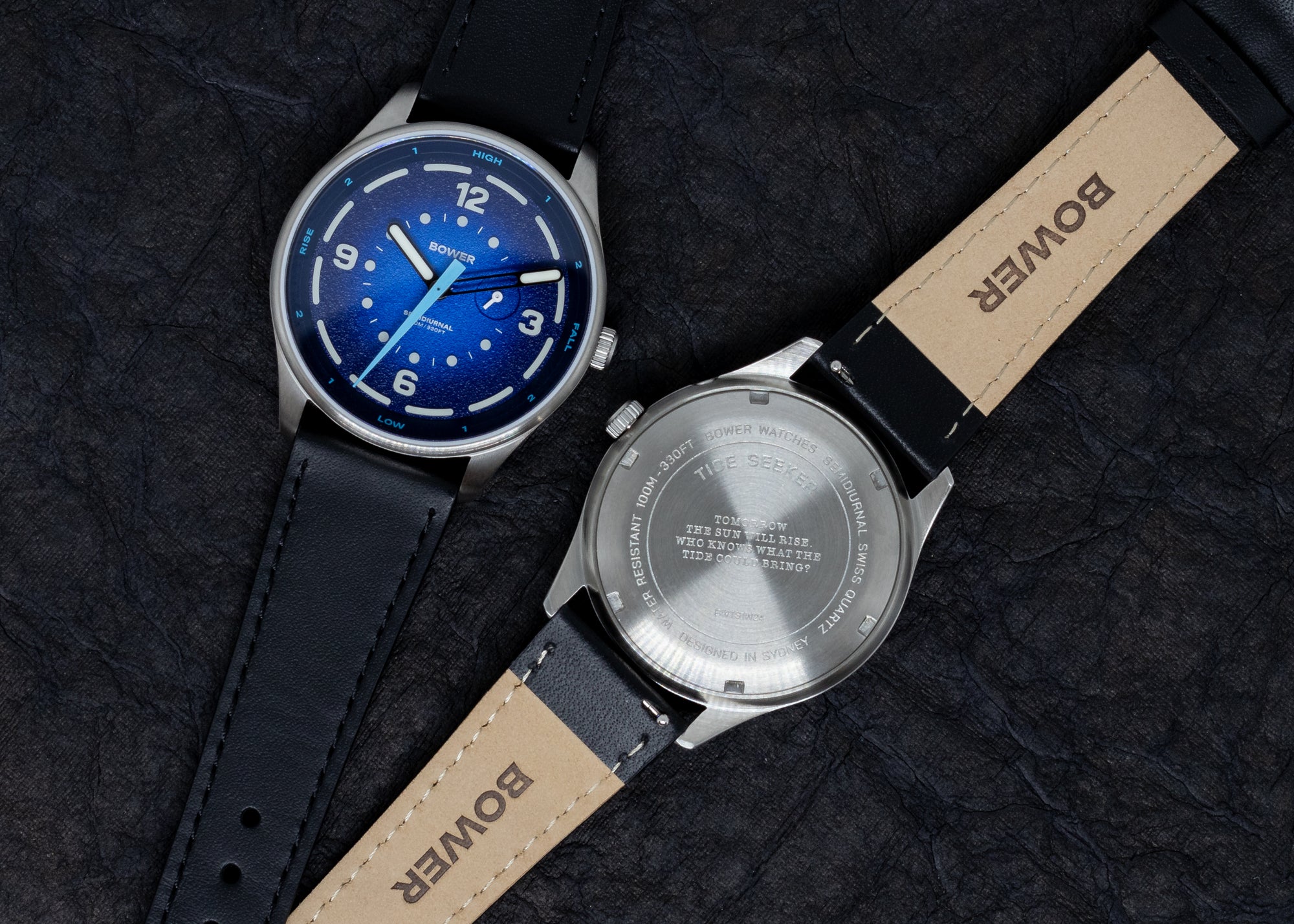 Front and back view of the Bower tide watch with a black leather strap, showcasing the deep blue textured dial and engraved stainless steel caseback featuring an ocean-themed quote.