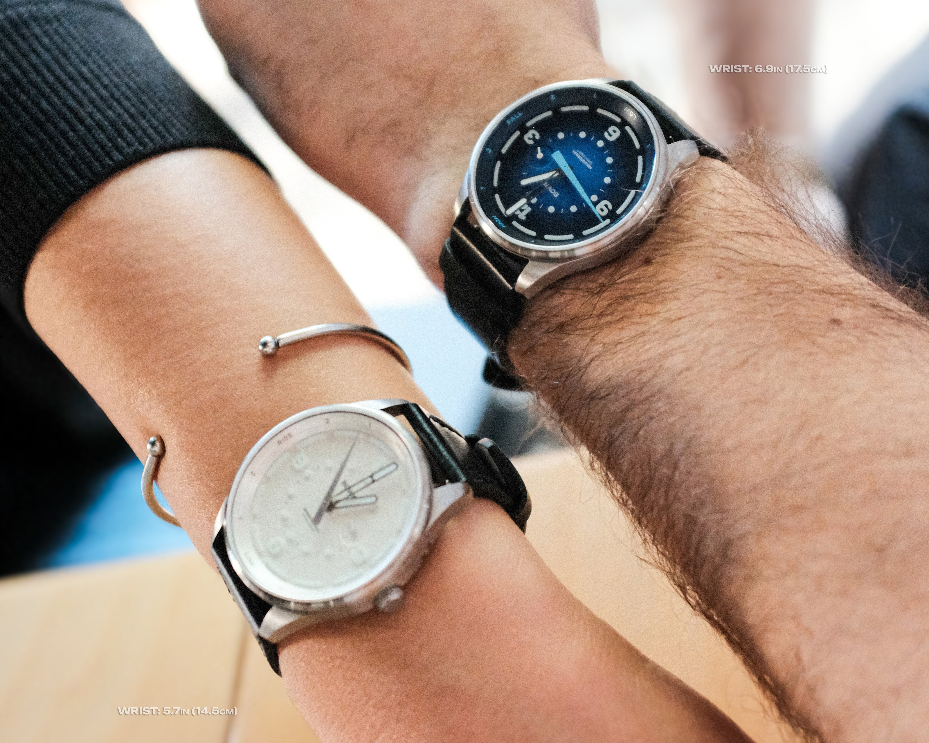 the arms of two lovers side by side. she wears a white bower watch, he wears a blue bower watch