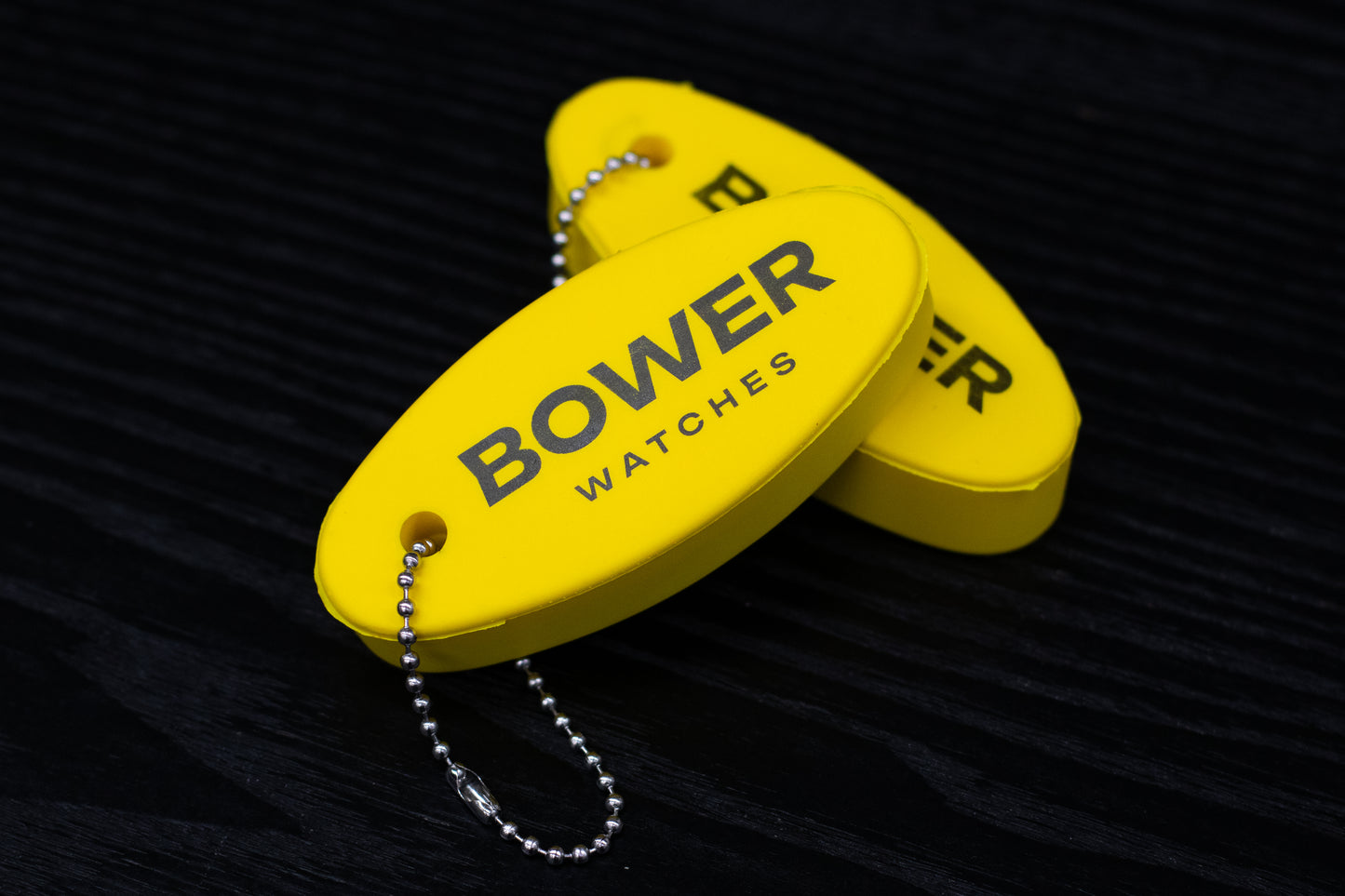 two yellow floaty keyrings with bower watches printed on